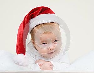 Happy newborn baby sleeping in a christmas hat
