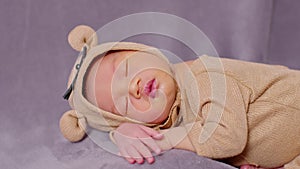 Happy newborn baby weaing cute Mouse costume lying sleeps on a grey blanket comfortable and safety.Cute Asian infant sleeping and