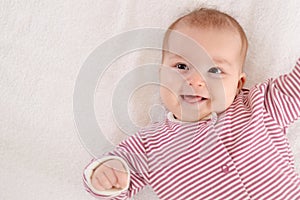 Happy newborn girl lying on her back and laugh