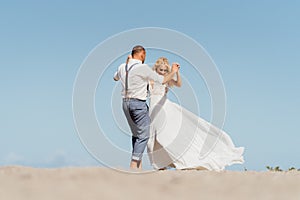 Happy newly married couple dancing on the beach. Wedding on the beach