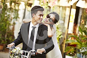 Asian newly wed couple riding a bicycle photo