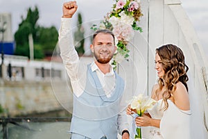 happy newlyweds exchange rings. beautiful wedding ceremony by water on dock.