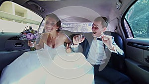 Happy Newlyweds Having Fun in a Limo