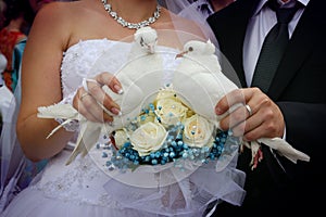 Happy newlyweds holding white doves