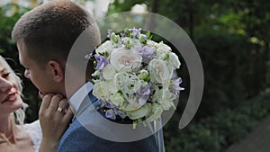 Happy newlyweds hug kiss in park.