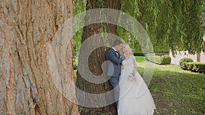 Happy newlyweds hug kiss in park.