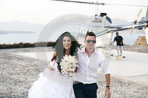 Happy newlyweds near the helicopter