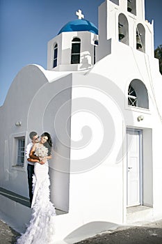 Happy newlyweds possing near the church