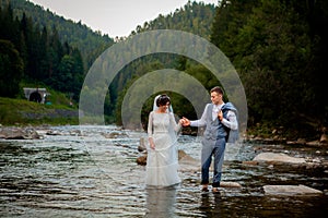 Happy newlyweds standing and smiling on the river . Honeymooners, photo for Valentine`s Day photo