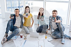 Happy nice people showing you their smartphones