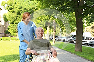 Happy nurse assisting elderly man in  at park