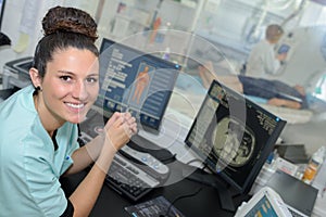 happy nurse when examining patient electrocardiogram at laptop