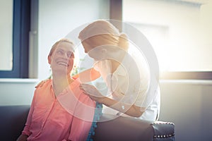 Happy nurse and patient in living room