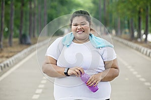 Happy obese woman holds a bottle of water