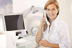 Happy office girl on landline phone call