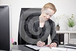 Happy Office Woman Writing a Document at her Table