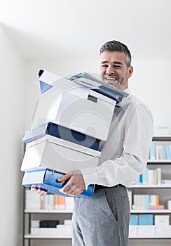 Happy office worker carrying boxes