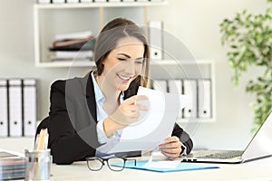 Happy office worker reading a letter