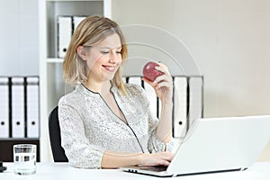 Happy office worker working holding an apple