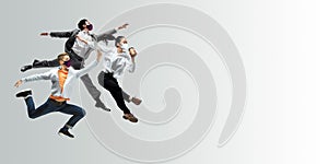 Happy office workers in face masks jumping and dancing in casual clothes or suit isolated on studio background. Creative