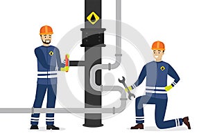 Happy oilman turns pipeline valve. Man worker uses wrench. Oil industry, workers in special clothing and helmet. Renovation work