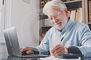 Happy old caucasian businessman smiling working online watching webinar podcast on laptop and learning education course conference