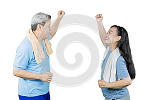 Happy old couple exercising together on studio