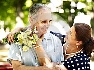 Happy old couple with flower.