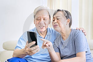 Happy old couple make video call by use cellphone