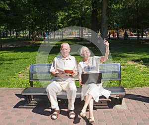 The happy old couple in the summer on a walk