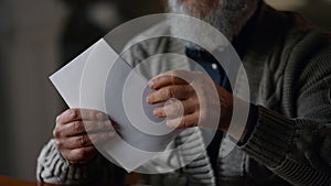 Happy old gentleman receiving letter in cabinet. Glad man opening envelope house