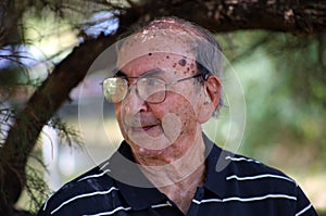 Happy old Argentine grandfather enjoying life waving hi, with big smile, big glasses and confident abuelo photo