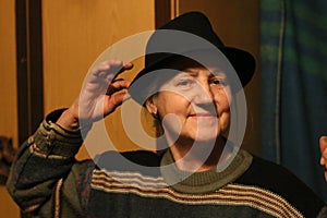 Happy old lady in black hat in twilight