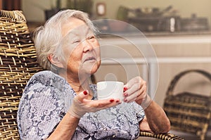 Happy old lady holding a cup of tea