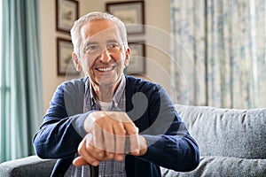 Happy old man holding walking cane