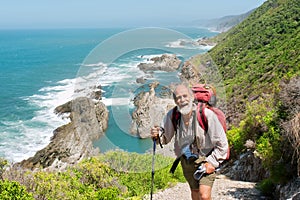 Happy old man just reaches the top of hill