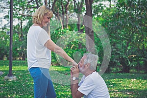 Happy old man kiss his wife hand at the park photo