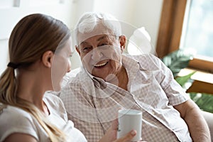 Happy old man talking with smiling grown up adult daughter.