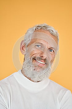 Happy old senior man isolated on yellow, vertical headshot portrait.