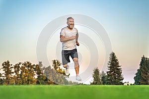 The happy old sportsman running on the grass.