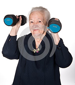 Happy old woman making fitness training with dumbbells