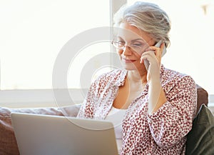 Happy old woman senior working at computer laptop at home