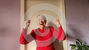 An happy old woman is smiling to camera.