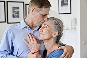 Happy older affectionate couple hugging, enjoying sweet tender moment of love.