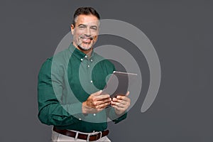 Happy older business man holding digital tablet, isolated on gray, portrait.