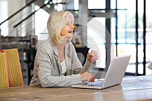 Happy older business woman working on laptop