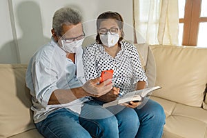 Happy older couple in face mask having fun with smartphone