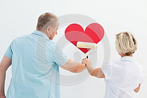 Happy older couple painting red heart