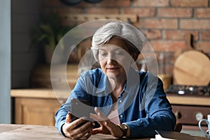 Happy older senior woman using smartphone apps.