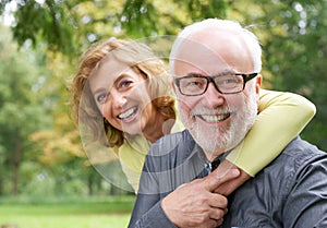 Happy older woman embracing smiling older man